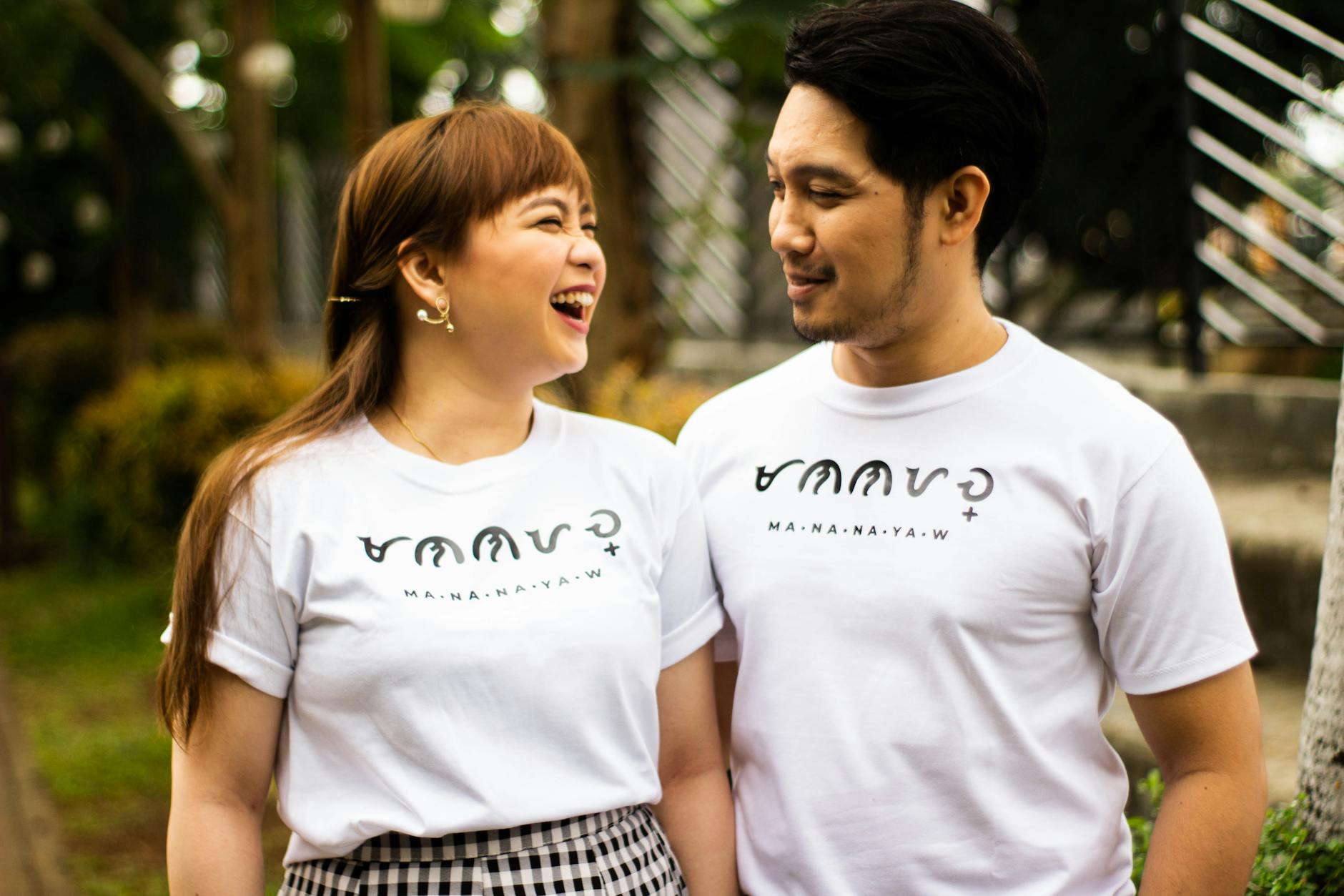 Para w podobnych koszulkach uśmiecha się na świeżym powietrzu