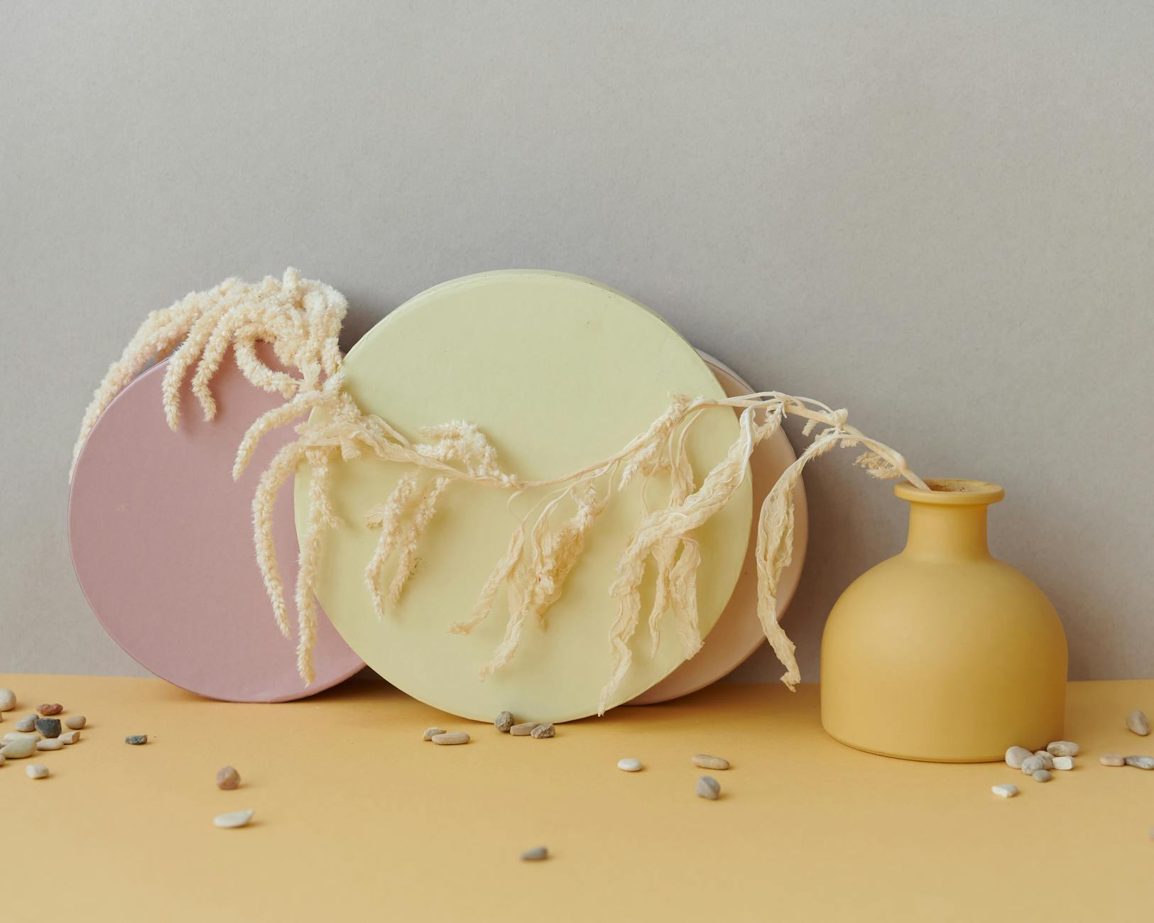 Pastelowa martwa natura z geometrycznymi formami i naturalnymi gałązkami