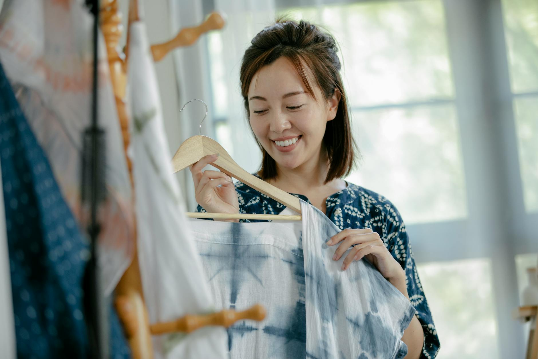 Jak budować szafę kapsułową, gdy kochasz ubrania z wyrazistymi nadrukami Projektantka ogląda barwne ubrania z nadrukami w nowoczesnym studiu