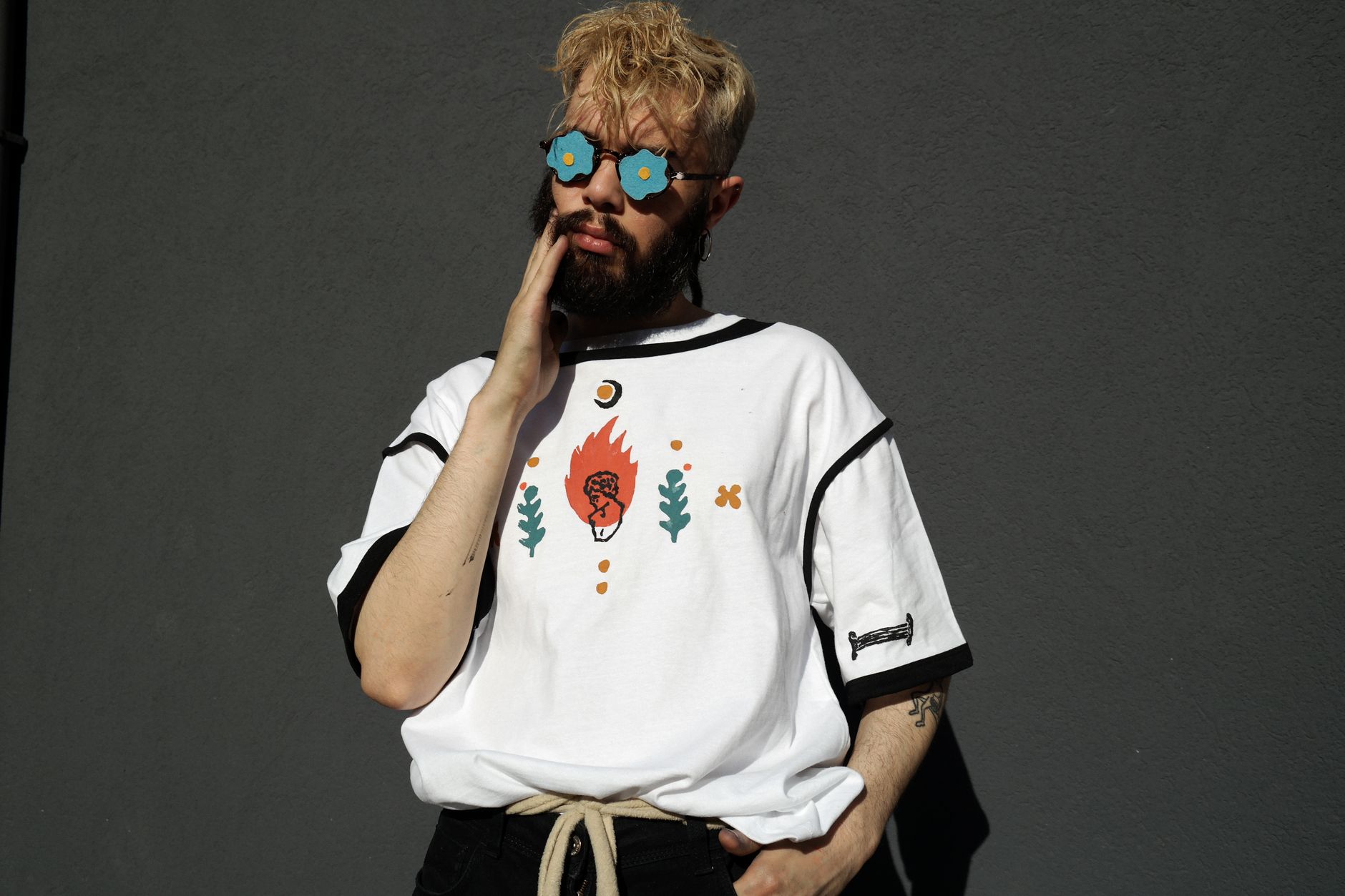 Stylowy mężczyzna w okularach i koszulce z nadrukiem retro na zewnątrz